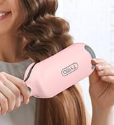 Personne utilisant un outil de coiffure rose de forme ovale sur de longs cheveux bruns bouclés. L'appareil semble être une brosse à cheveux ou un accessoire de coiffage.